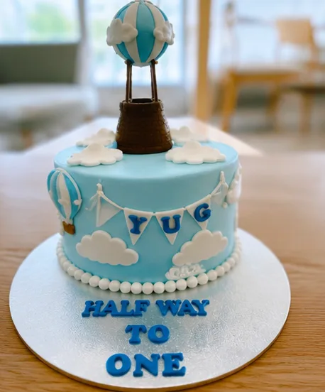 A hot air balloon themed 'halfway to one' cake
